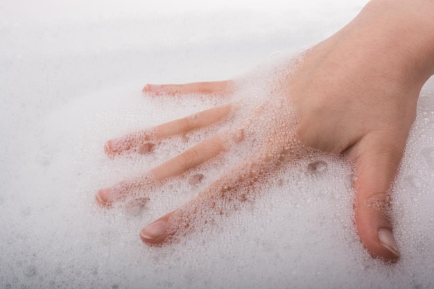 Criança lavando as mãos na espuma