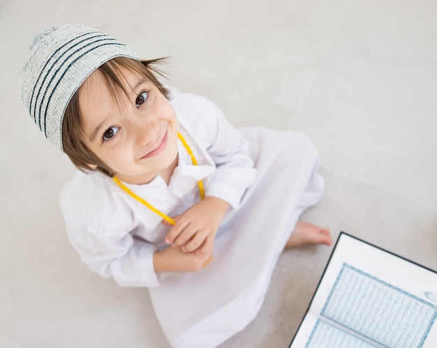 Criança lendo koran