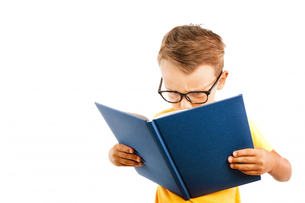 Criança lendo um livro contra uma parede brilhante