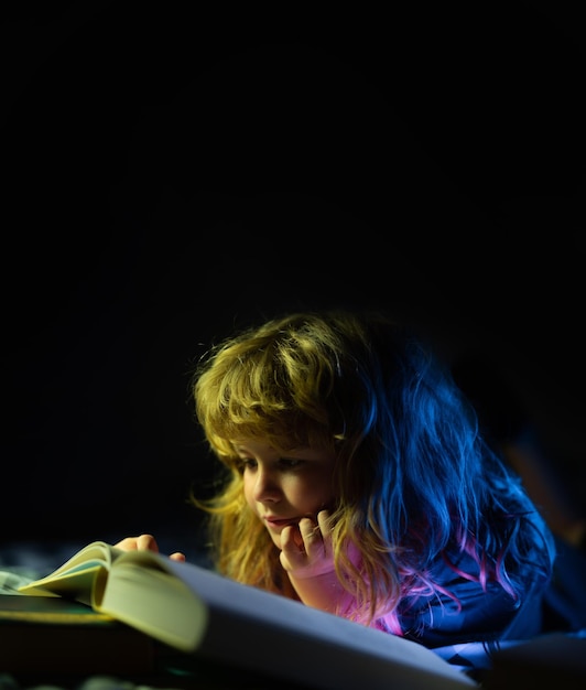 Criança lendo um livro mágico na cama garoto leu livros em casa conceito de educação e leitura