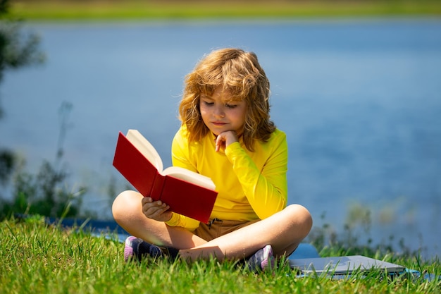 Criança leu um livro de educação infantil para crianças, férias de verão com livro de leitura, lição de casa ao ar livre, verão c
