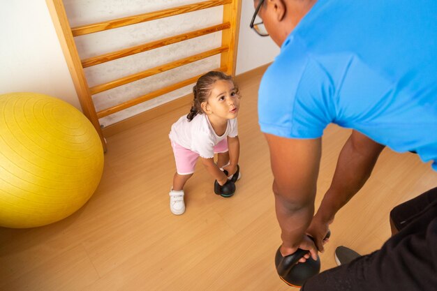 Foto criança levantando kettlebell perto do pai