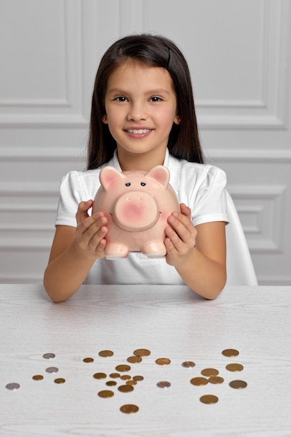 Criança menina com cofrinho em casa