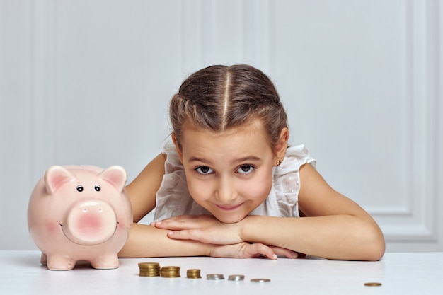 Criança menina com cofrinho em casa