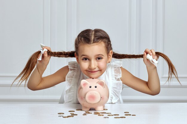 Foto criança menina com cofrinho em casa