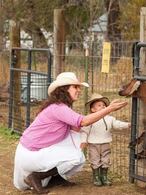 Criança menino com sua mãe na fazenda.