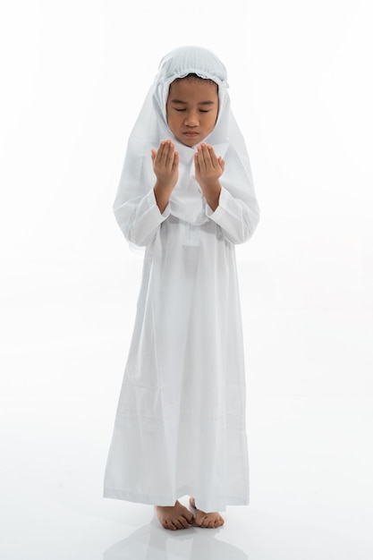 Criança muçulmana rezando e vestindo ihram