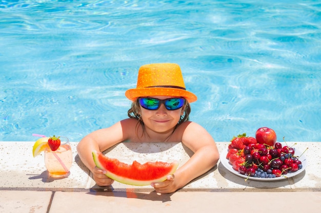 Criança na piscina brincando na água de verão Férias e viajando com crianças Frutas de verão para crianças