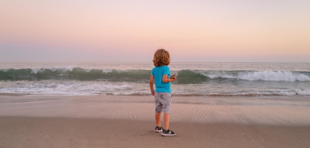 Criança na praia. Menino de criança brincando na costa. Criança se divertindo ao ar livre. Conceito de férias de verão.