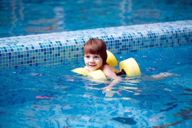 Criança nada na piscina