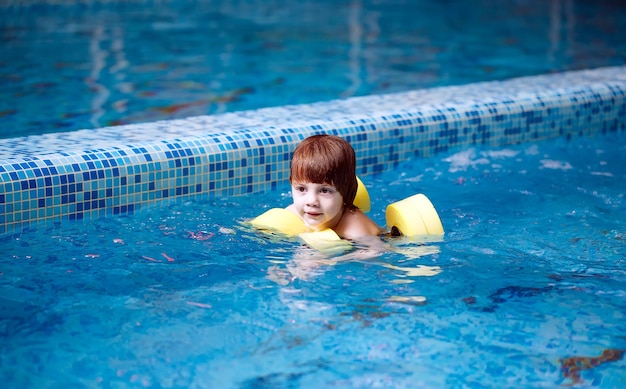 Criança nada na piscina.