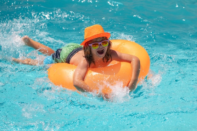 Criança nadar com anel flutuante na piscina crianças férias de verão e conceito de férias feliz pequeno b