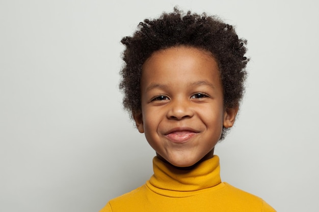 Criança negra travessa sorrindo em fundo branco