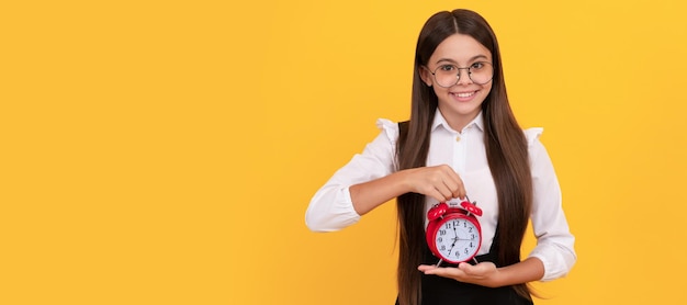 Criança nerd feliz com despertador garoto da escola de uniforme e óculos mostrando a hora em que você está atrasado