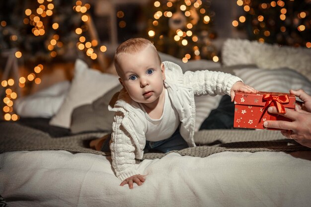 criança no fundo de uma árvore de Natal decorada