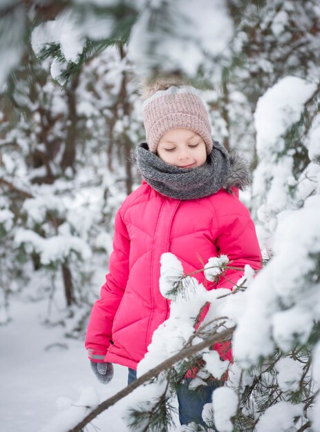 Criança no inverno. Uma menina brincando no inverno lá fora. Um lindo retrato de criança de inverno. Criança feliz, diversão de inverno ao ar livre.