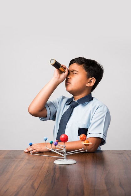 Criança ou menino indiano da escola estudando planetas ou ciências planetárias com o modelo 3D do nosso sistema solar