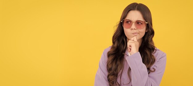 Criança pensativa com cabelo encaracolado em óculos de sol beleza e moda modelo de moda feminina Rosto de criança