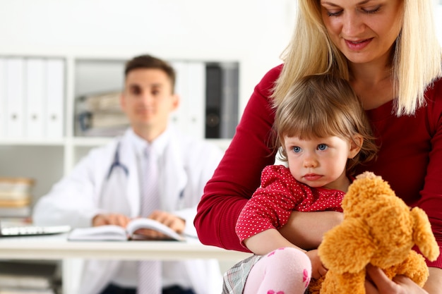 Criança pequena com a mãe na recepção do pediatra