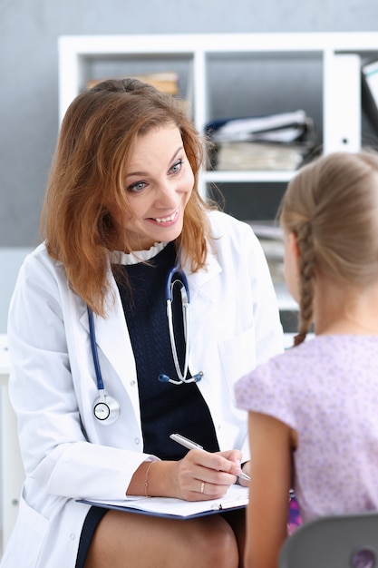 Criança pequena com a mãe na recepção do pediatra