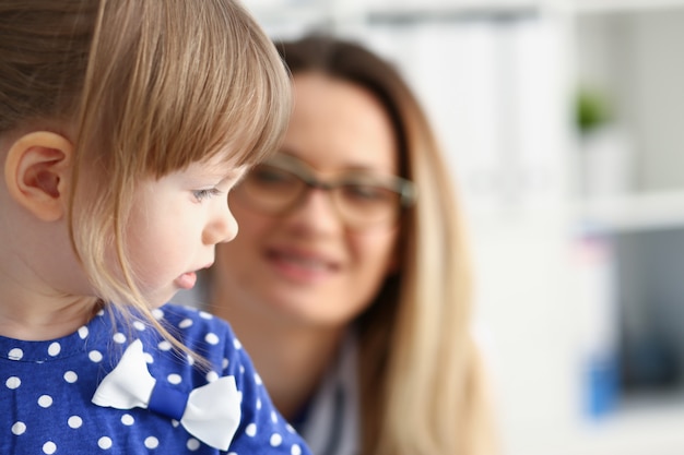 Criança pequena com a mãe na recepção do pediatra