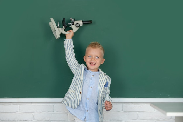 Criança pequena com estudante de microscopia aprendendo em sala de aula estudar inglês na escola