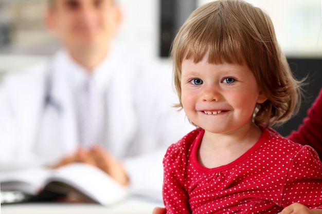 Criança pequena com mãe na recepção do pediatra