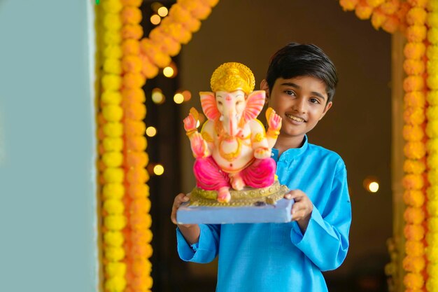 Criança pequena indiana comemora o festival de senhor ganesha.