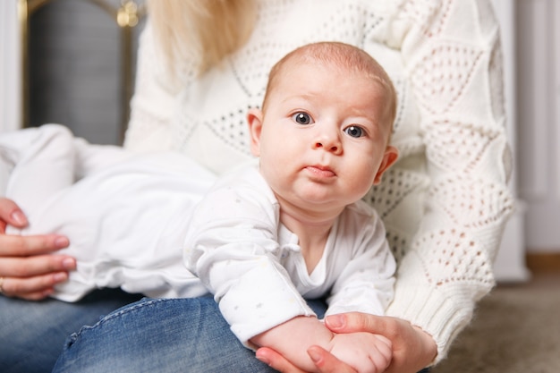 criança pequena nas mãos das mães.