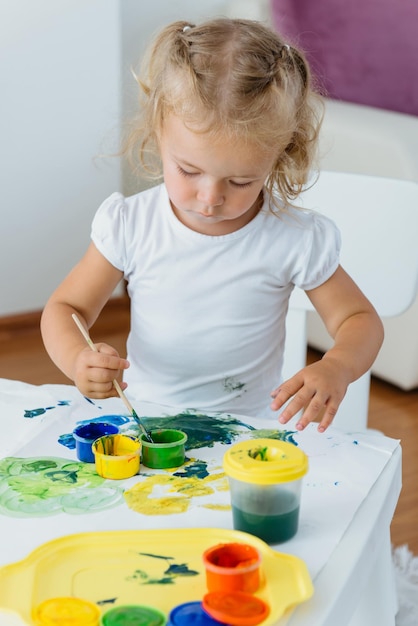 Criança pequena pintando em casa, tempo livre criativo