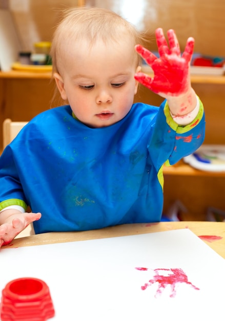 Criança pintando com a mão