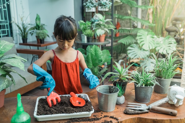 Criança plantando e jardinando em casa