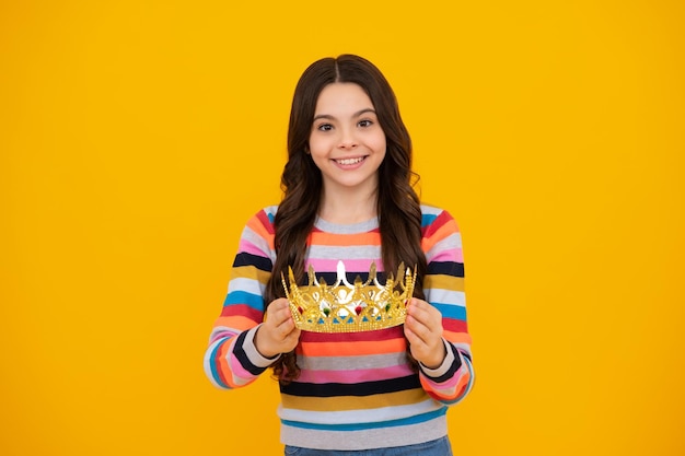 Criança princesa adolescente comemora vitória e vitória de sucesso Menina adolescente na coroa de rainha Adolescente feliz emoções positivas e sorridentes de menina adolescente