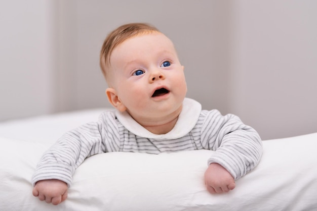 Criança recém-nascida relaxando na cama Manhã em família em casa Criança recém-nascida durante a hora da barriga