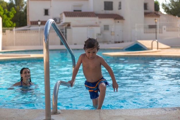 Criança saindo da piscina pelas escadas