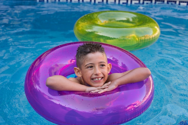 Foto criança se divertindo com flutuador à beira da piscina