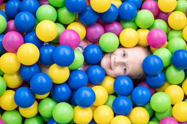Criança se escondeu em bolas coloridas para que uma cabeça se destacasse