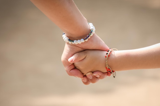 Criança segurando a mão da mãe de um membro da família como uma família unida