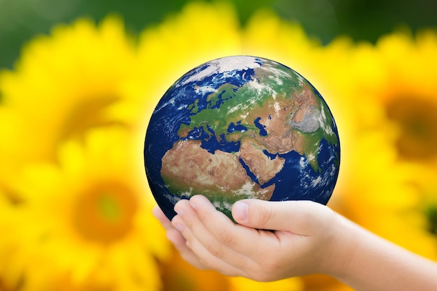 Criança segurando a Terra nas mãos contra o fundo verde da primavera Elementos desta imagem fornecidos pela NASA