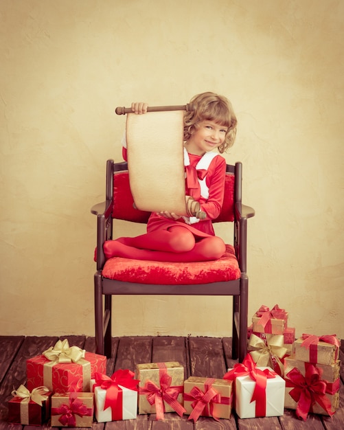 Criança segurando o rolo de papel de natal. conceito de férias de natal