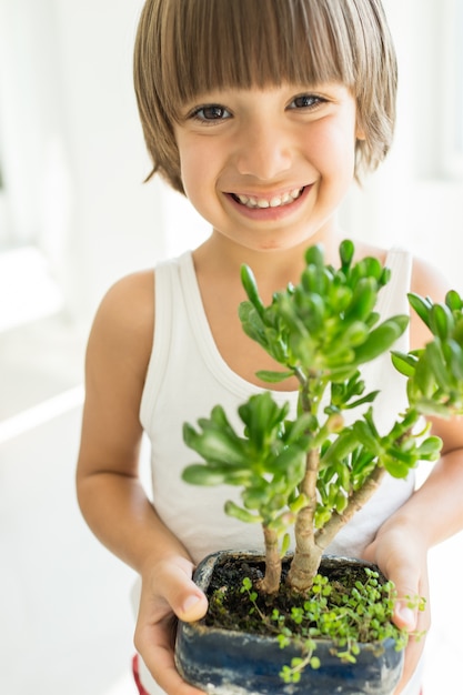 Criança, segurando, planta, crescendo, orgânica, ervas, cozinhar, lar, saudável, estilo vida