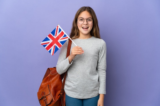 Criança segurando uma bandeira do Reino Unido sobre um fundo isolado com expressão facial surpresa