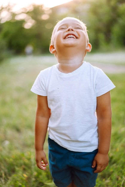 Criança sorridente com brinquedo no parque de verão em dia ensolarado Menino bonitinho aproveitando o clima fresco da primavera