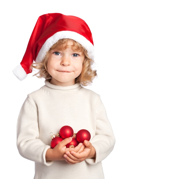 Criança sorridente com chapéu de papai noel segurando as decorações de natal isoladas no fundo branco