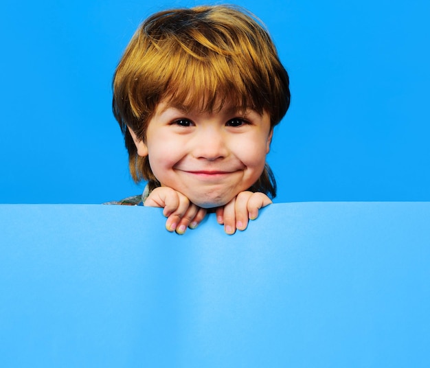 Criança sorridente com desconto de venda de compras de placa de publicidade criança engraçada com cartaz em branco