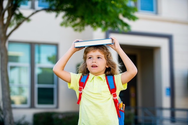 Criança sorridente feliz de óculos está indo para a escola pela primeira vez Aluno vai estudar Menino com bolsa vai para a escola primária Criança da escola primária De volta à escola Conceito de educação infantil