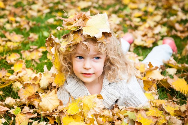 Criança sorridente no outono amarelo sai ao ar livre. Conceito de moda outono