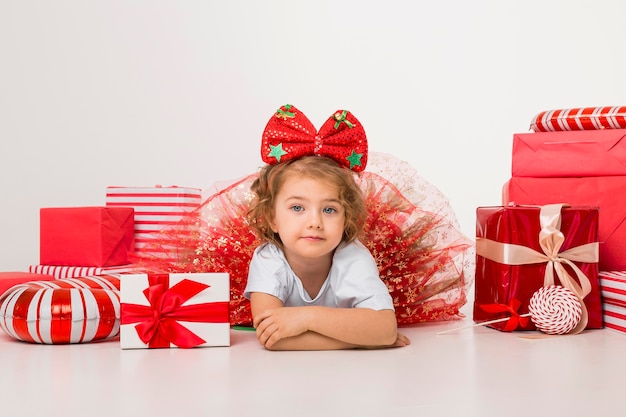 Foto criança sorridente rodeada de elementos de natal