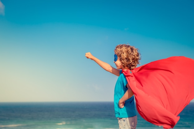 Criança super-herói nas férias de verão Criança super-herói se divertindo na praia Estilo de vida ativo e saudável