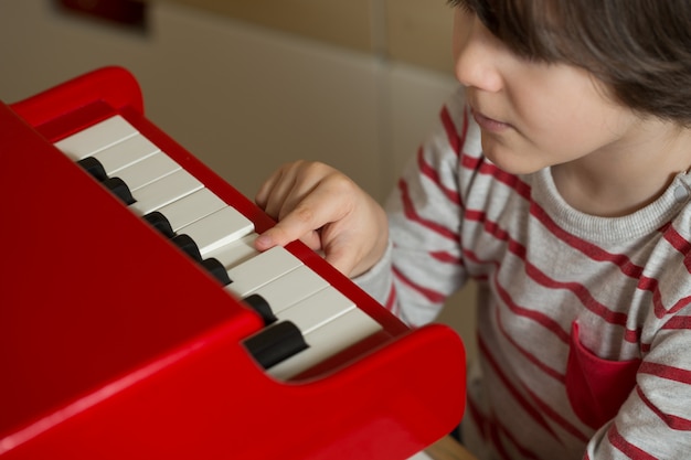 Foto criança, tocando, piano brinquedo